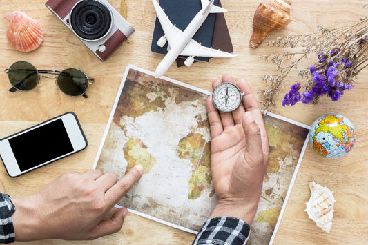 Préparation d'un voyage : carte du monde, boussole, appareil photo et lunettes de soleil