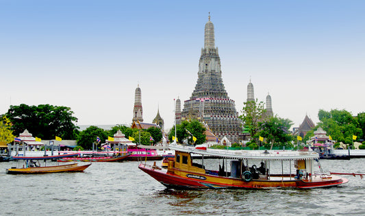 Le temple Wat Arun au bord du fleuve Chao Phraya à Bangkok, avec des bateaux