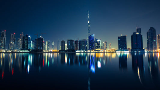 Les gratte-ciel de Dubaï et la Burj Khalifa illuminés de nuit, reflétés dans l'eau