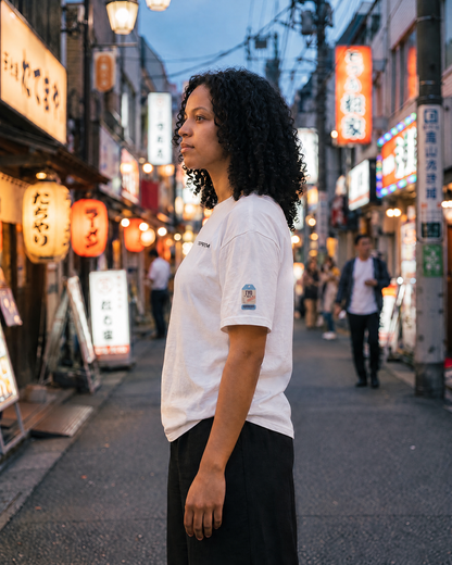 T-shirt Tokyo HND blanc porté de profil à Tokyo, étiquette sur la manche - TRIPKIM