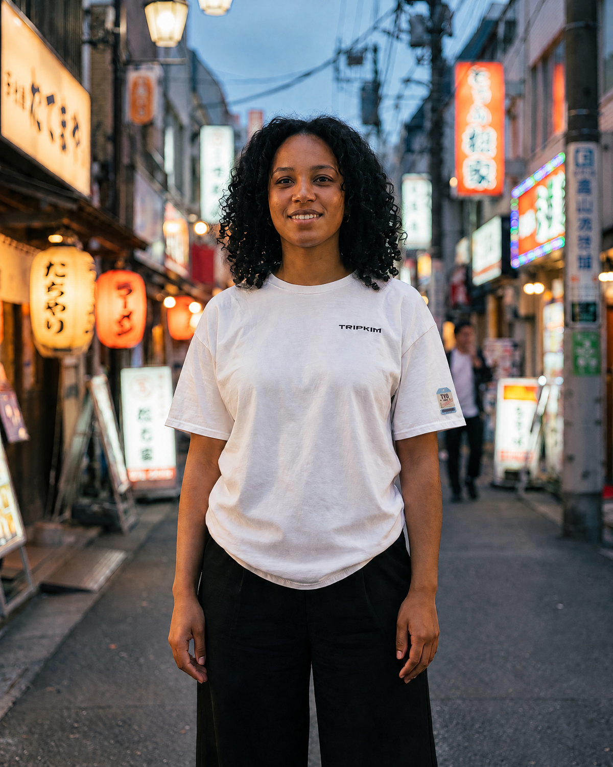T-shirt Tokyo HND blanc porté de face dans une ruelle aux néons de Tokyo - TRIPKIM