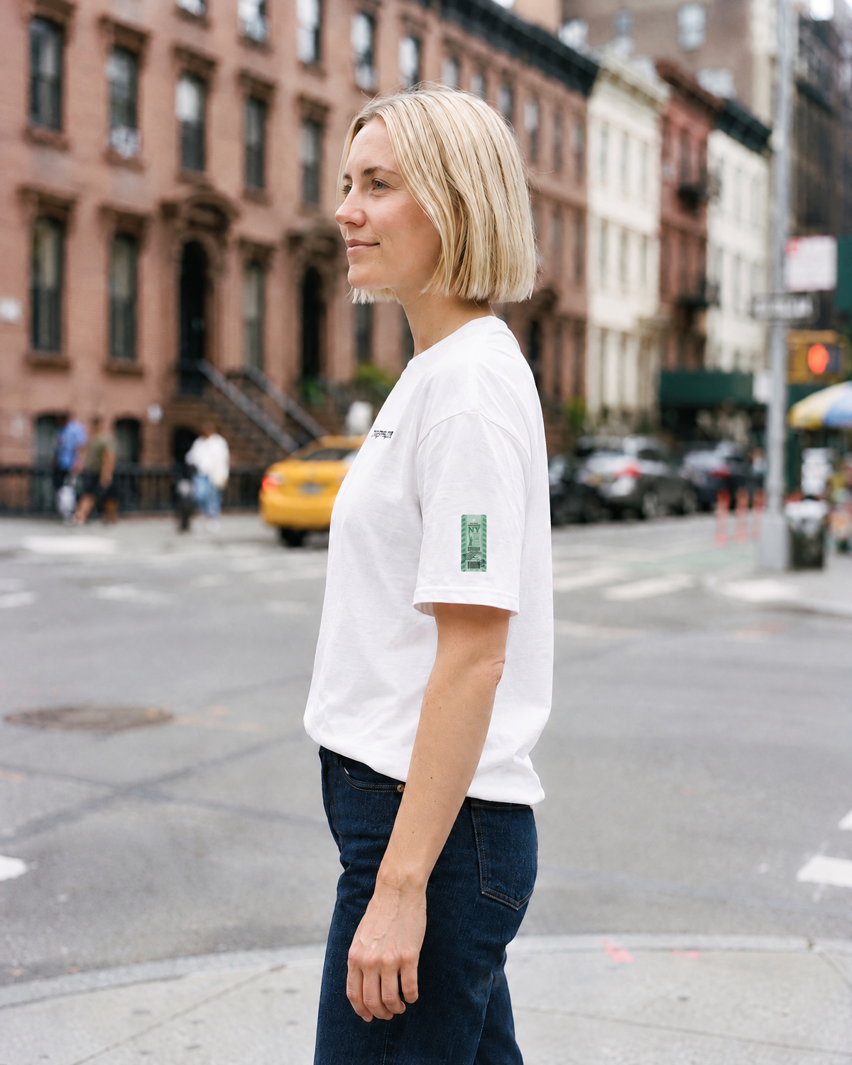 T-shirt New York JFK blanc porté de profil, étiquette NY sur la manche - TRIPKIM